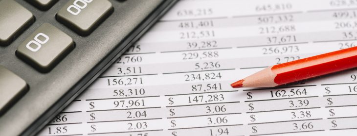 close-up-of-red-colored-pencil-with-calculator-over-the-financial-report